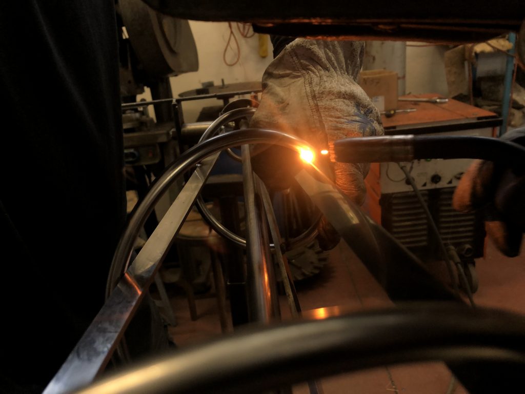 Saldatura di una struttura metallica per lampadario in officina